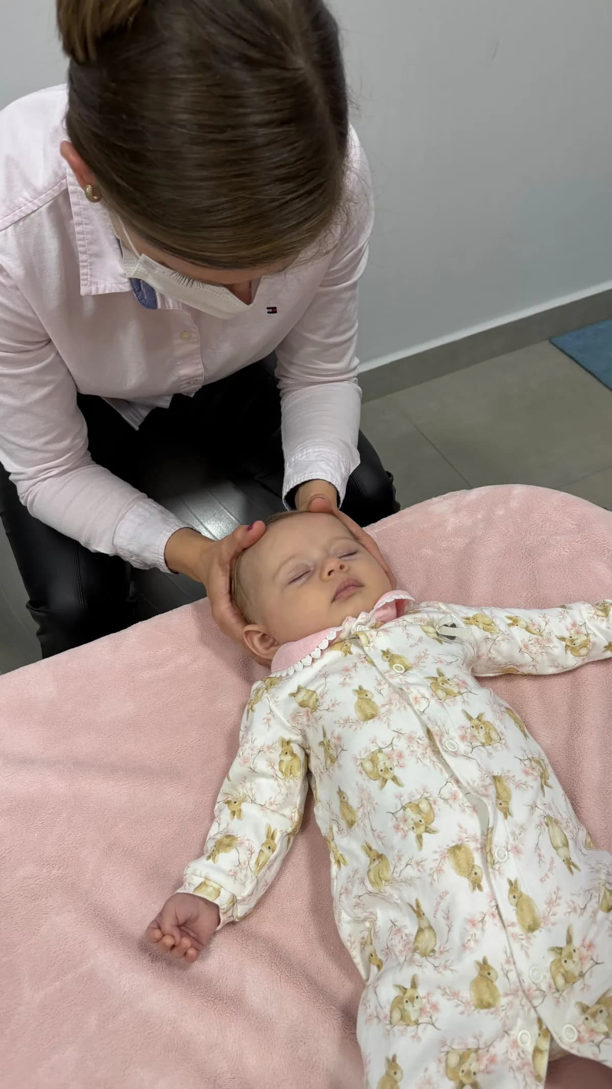 Avaliação osteopática da cabeça de um bebê durante a primeira consulta